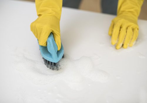 high-angle-woman-with-cleaning-gloves-using-brush